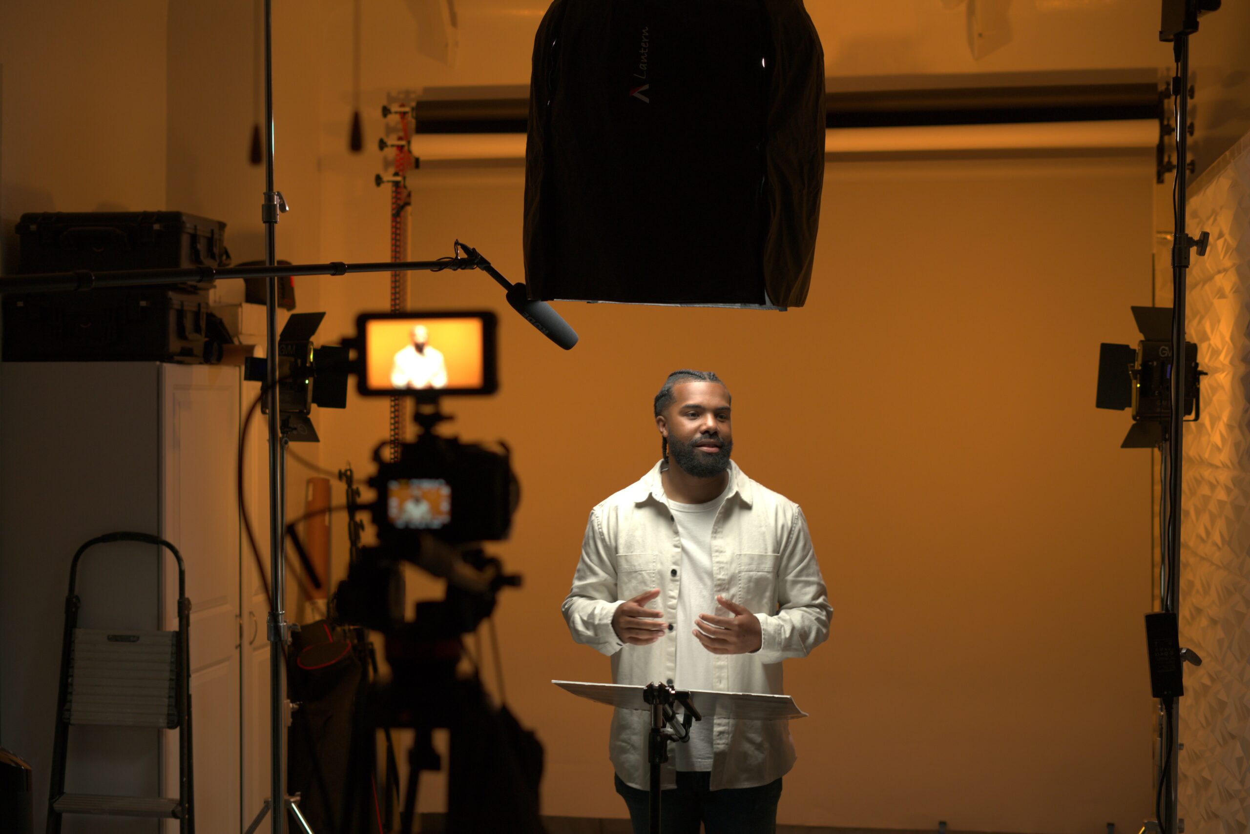 Professional videographer filming a man in a studio
